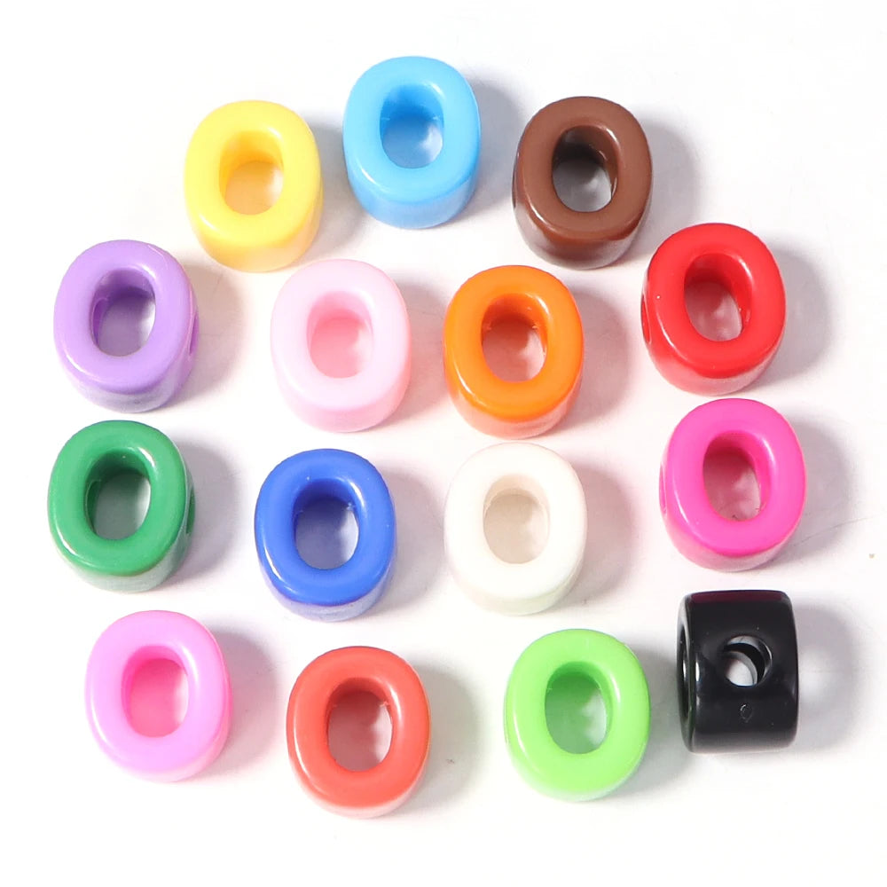 A collection of colorful acrylic alphabet beads in various shades including yellow, blue, pink, and green.