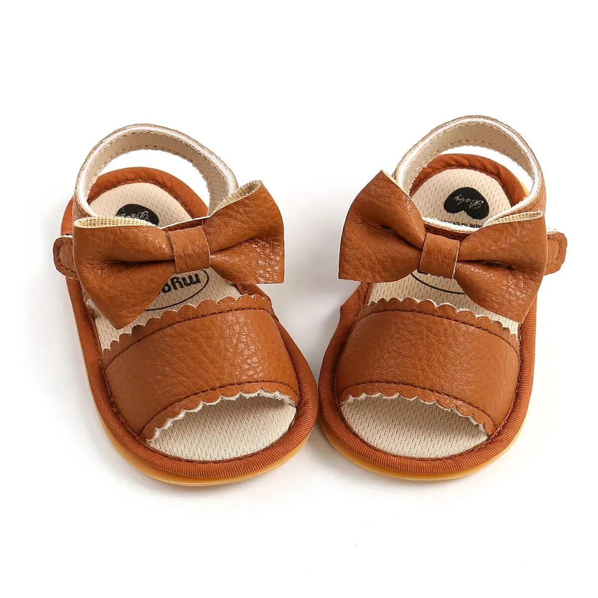 Pair of tan leather baby summer sandals with bowknot detail and soft anti-slip sole