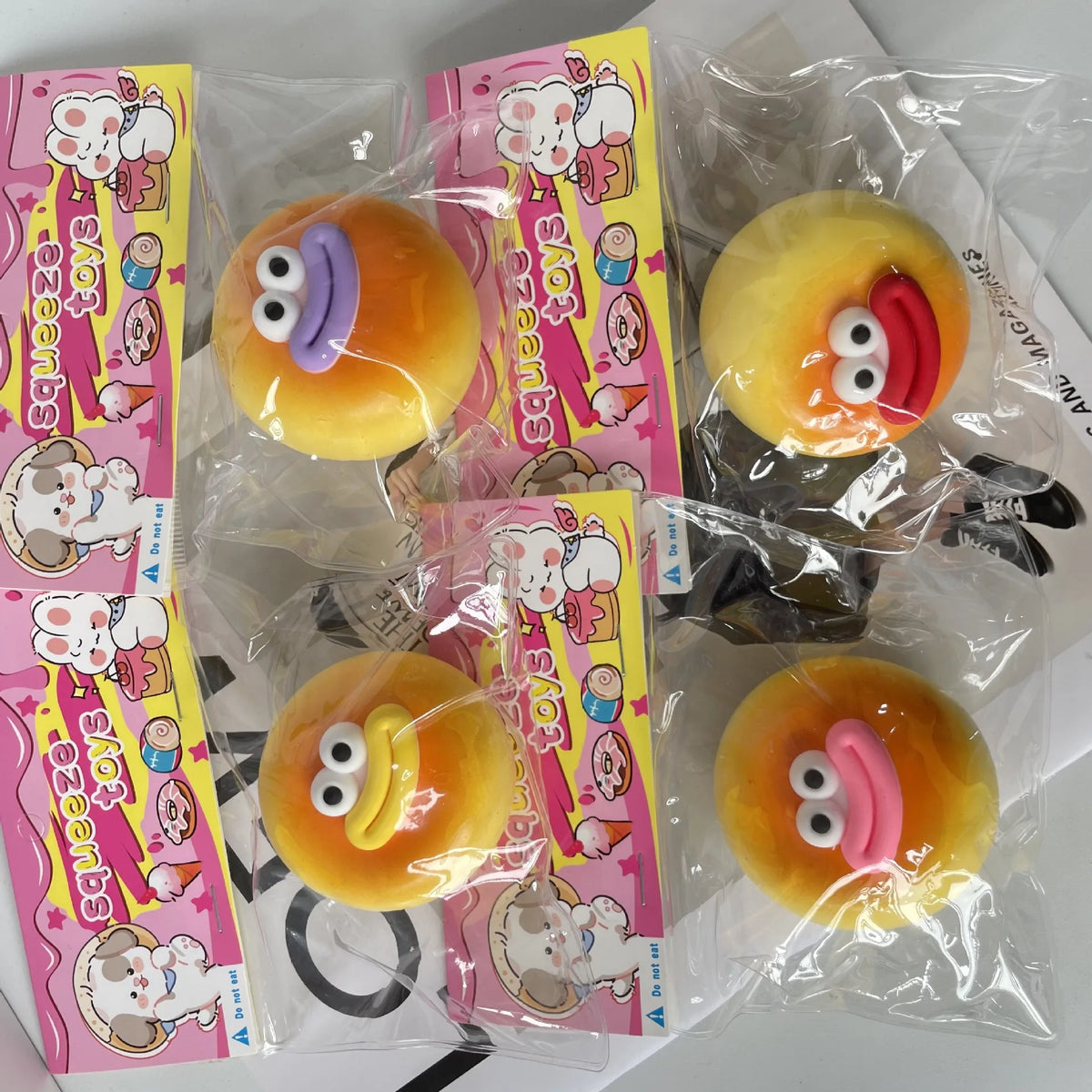 A collection of yellow and orange squishy toys shaped like steamed bread, packaged in clear plastic bags with colorful labels