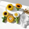 A collection of reusable silicone sunflower molds in yellow and white for candle making, resin, and soap.
