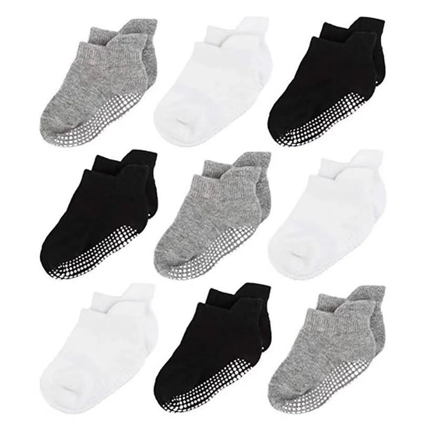 A pack of six cotton anti-slip socks for baby and kids in various colors including gray, white, and black.