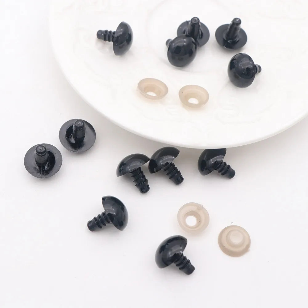 A collection of black and translucent plastic safety eyes with locking washers for amigurumi projects.