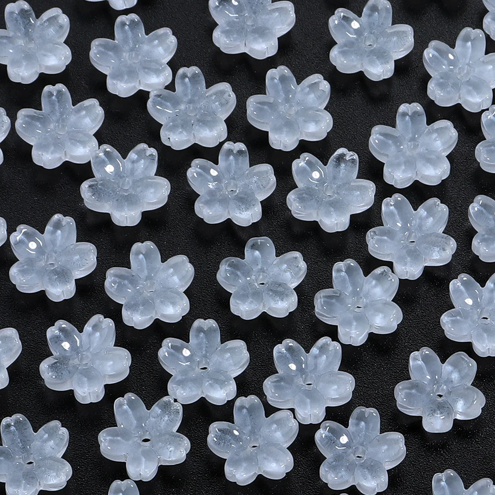 A close-up view of a 50-piece set of clear glass cherry blossom flower beads for jewelry making