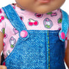 A baby doll wearing a pink shirt with a cat print and a blue denim overalls.