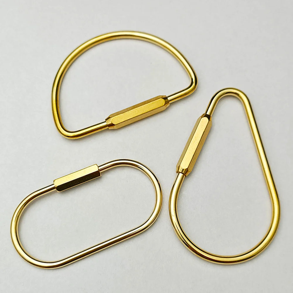 Brass keychain with a locking carabiner clip shown against a light gray background.