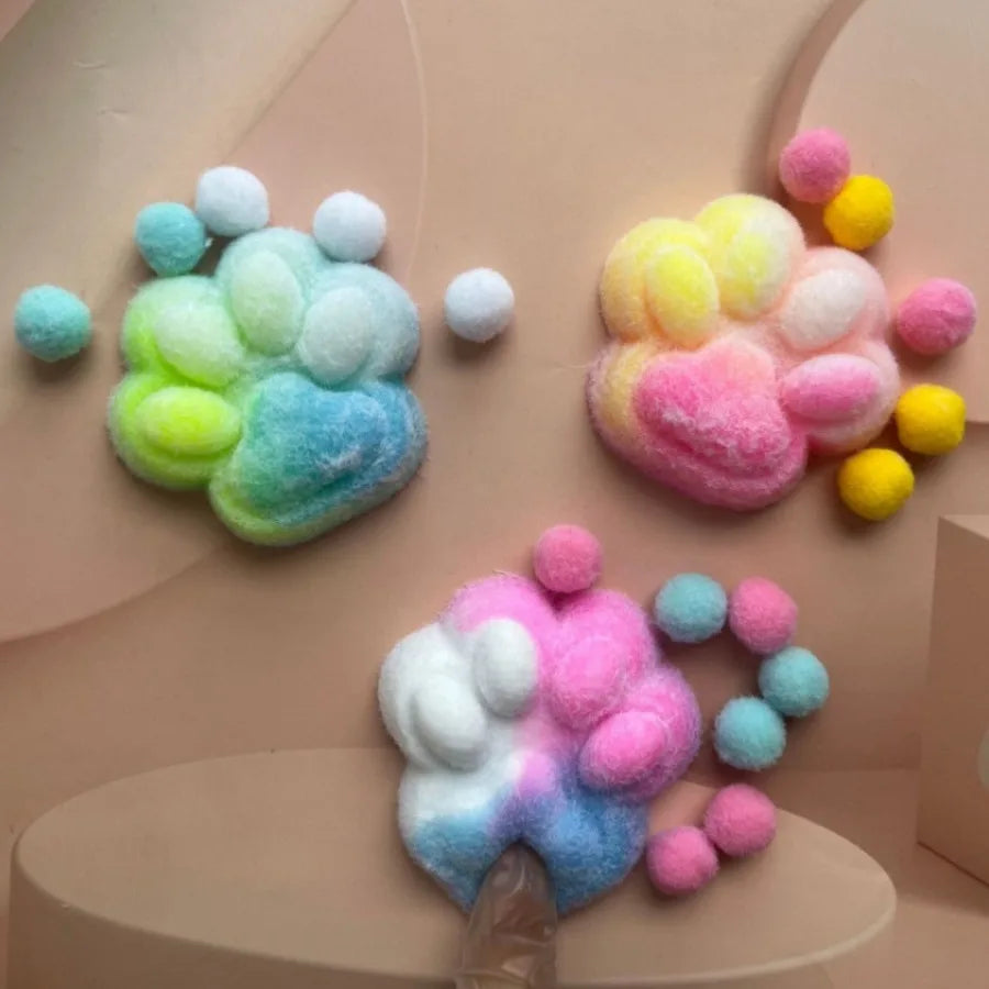 A collection of colorful, squishy cat paw shaped fidget toys made of soft, fuzzy material.