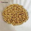 A pile of small, round gold-plated brass spacer beads for jewelry making.