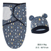A navy blue cotton newborn swaddle blanket and hat set featuring a pattern of yellow and blue cats.