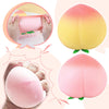 A pink peach-shaped squishy toy is shown being squeezed by hands, demonstrating its texture and size.