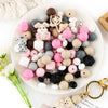 A white plate filled with various colored silicone beads shaped like cartoon animals for DIY jewelry making