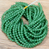 A strand of small, round, translucent green Aventurine gemstone beads for jewelry making