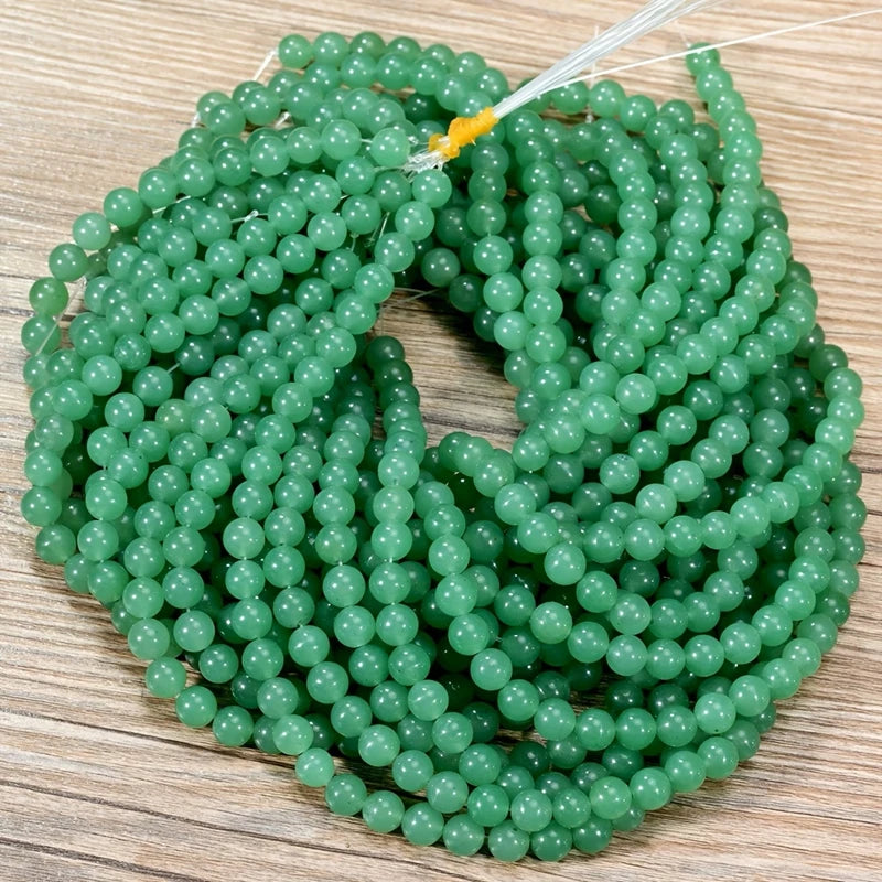 A strand of small, round, translucent green Aventurine gemstone beads for jewelry making