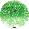 A pile of colorful round loose glass seed beads in various shades of green and yellow-green.