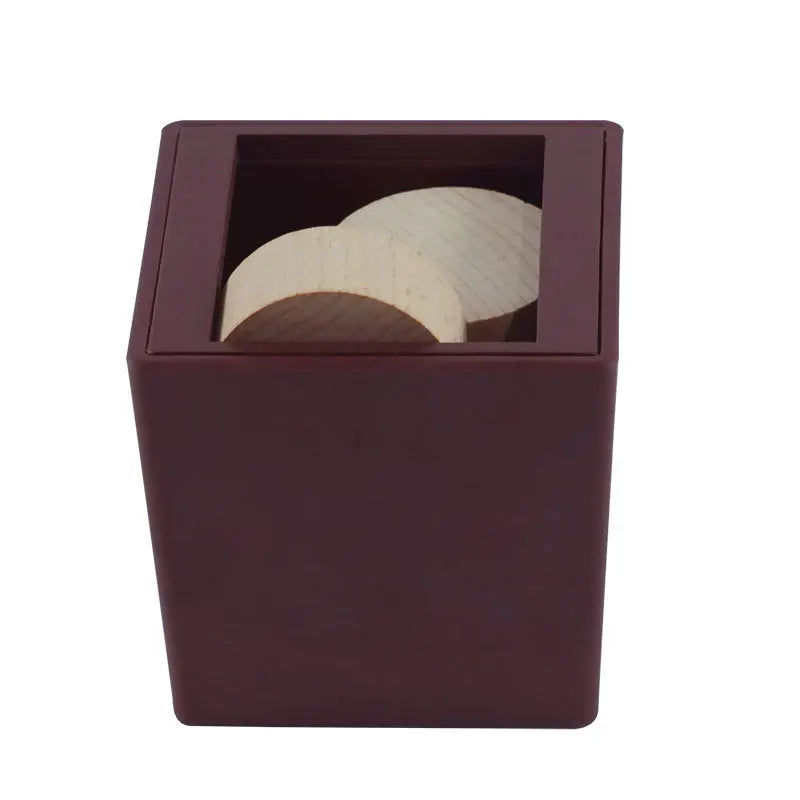 A dark brown wooden box containing six light-colored wooden puzzle pieces.
