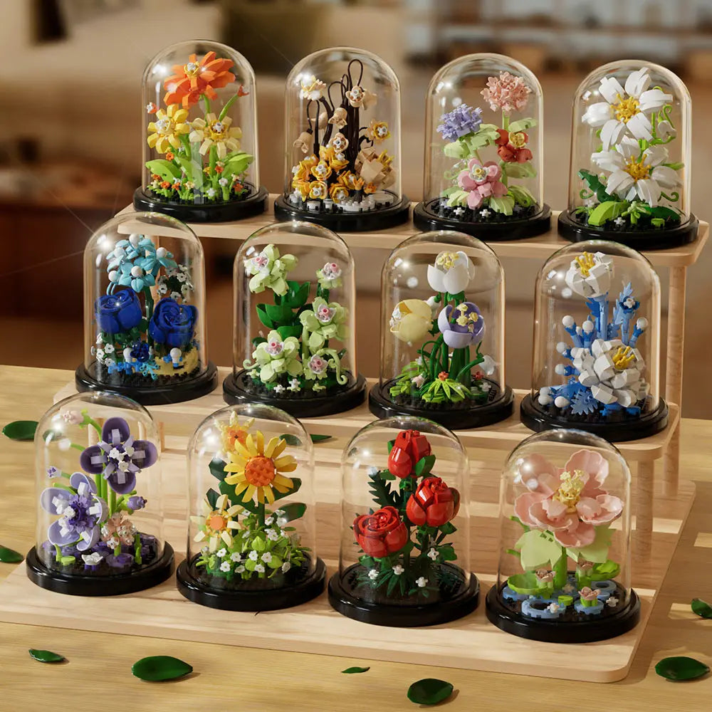 A collection of glass cloches displaying various colorful, blooming roses and flowers on a wooden surface.