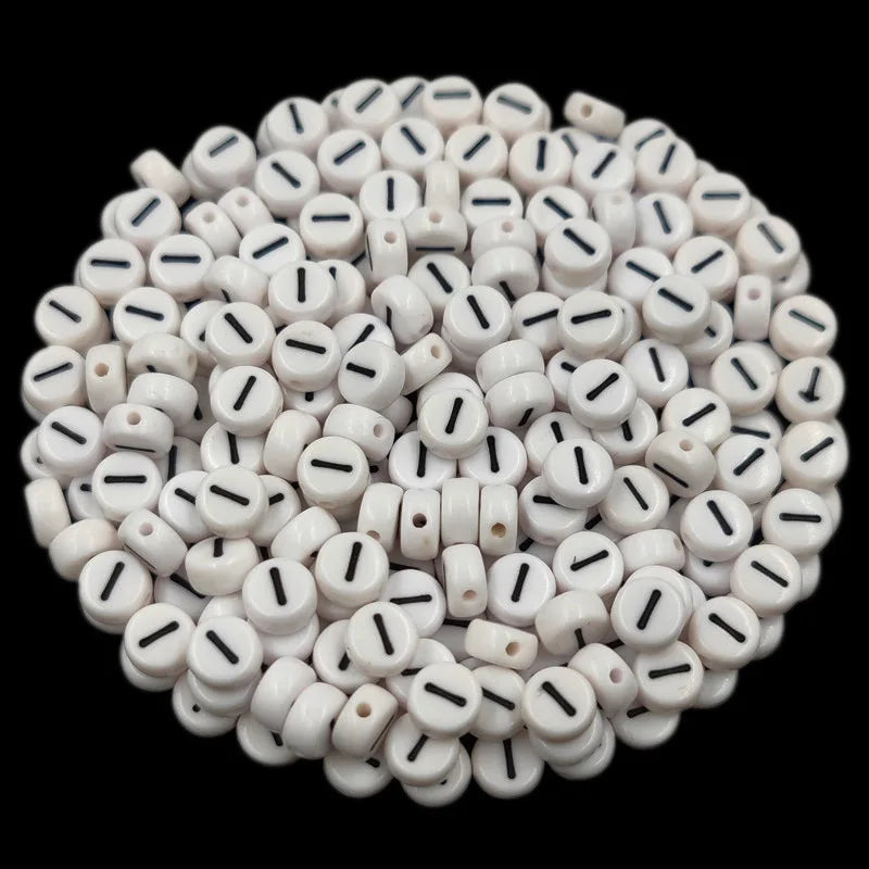 A circular arrangement of small white acrylic alphabet letter beads for jewelry making