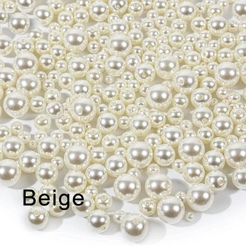 A pile of beige ivory pearl beads scattered on a white surface.