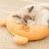 A small tabby kitten is sleeping on an orange plush U-shaped pet pillow.