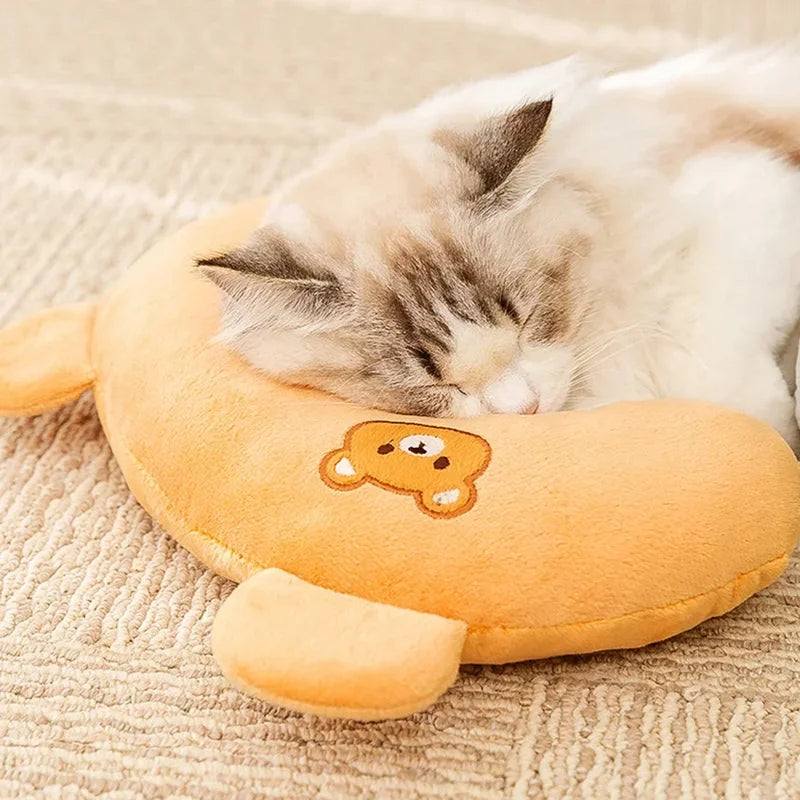 A small tabby kitten is sleeping on an orange plush U-shaped pet pillow.
