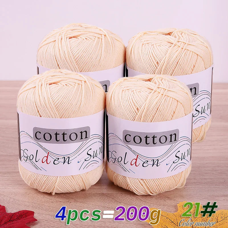 Four spools of light beige cotton knitting yarn for crochet and handmade projects