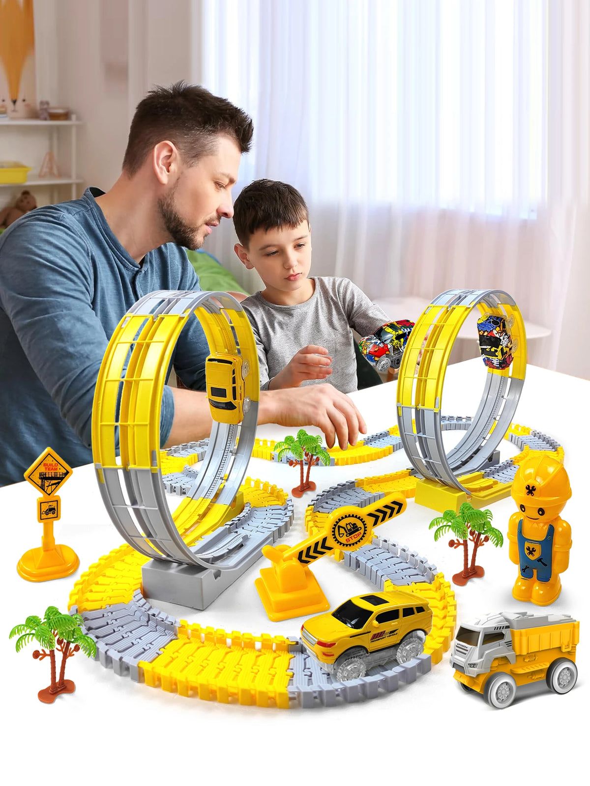 A yellow and gray flexible dinosaur race track toy set with electric cars being played with by a man and a boy.