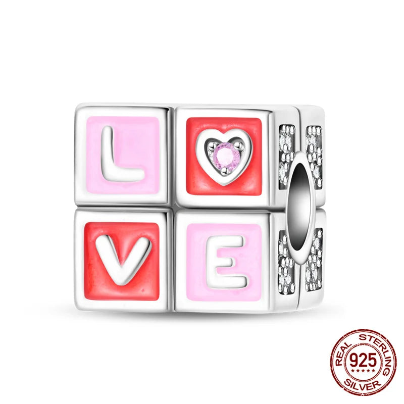 A set of four heart-shaped charms in pink and silver, featuring the letters L, O, V, and E, made of 925 sterling silver.
