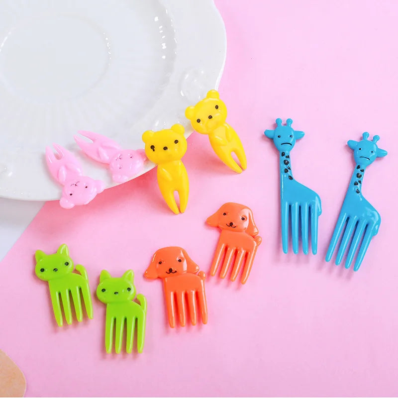A set of colorful kawaii mini fruit forks in yellow, pink, orange, and blue against a pink background.