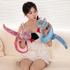 A young woman is holding a colorful, plush cartoon snake toy with iridescent scales and pink and blue accents.