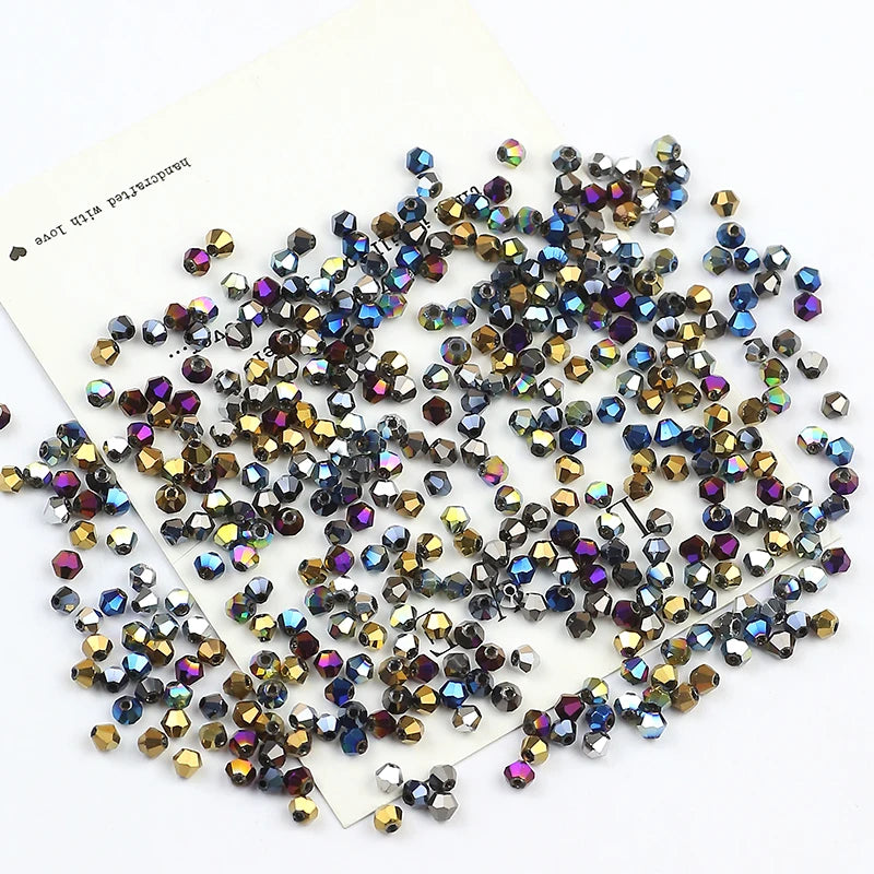 A scatter of iridescent electroplated crystal glass beads in various shades of blue, purple, and gold.