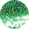 A close-up view of loose, colorful round green glass seed beads for jewelry making.