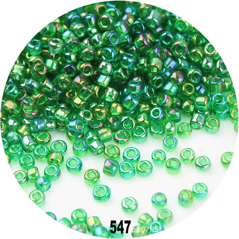 A close-up view of loose, colorful round green glass seed beads for jewelry making.