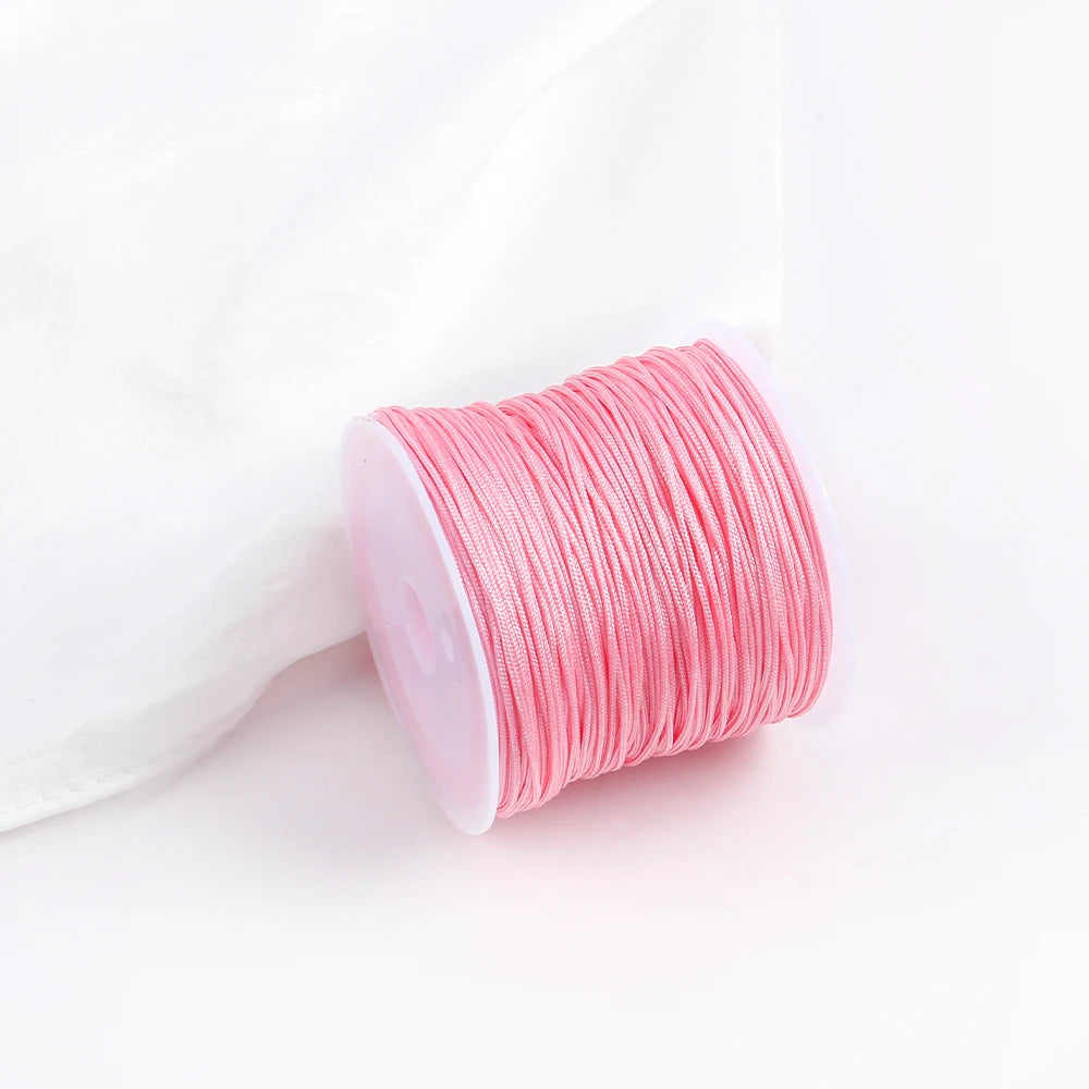 A roll of pink macrame cord for jewelry making and crafts.