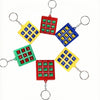 A set of five mini tic tac toe puzzle games in various colors and shapes attached to keychains.