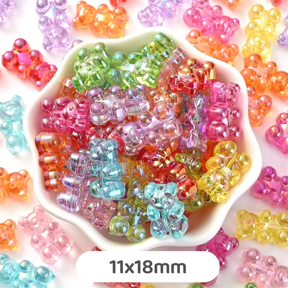 A pile of pastel bear-shaped acrylic craft beads in various colors like pink, green, orange, and yellow.