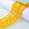 Yellow faceted glass crystal beads strung together on a white background.