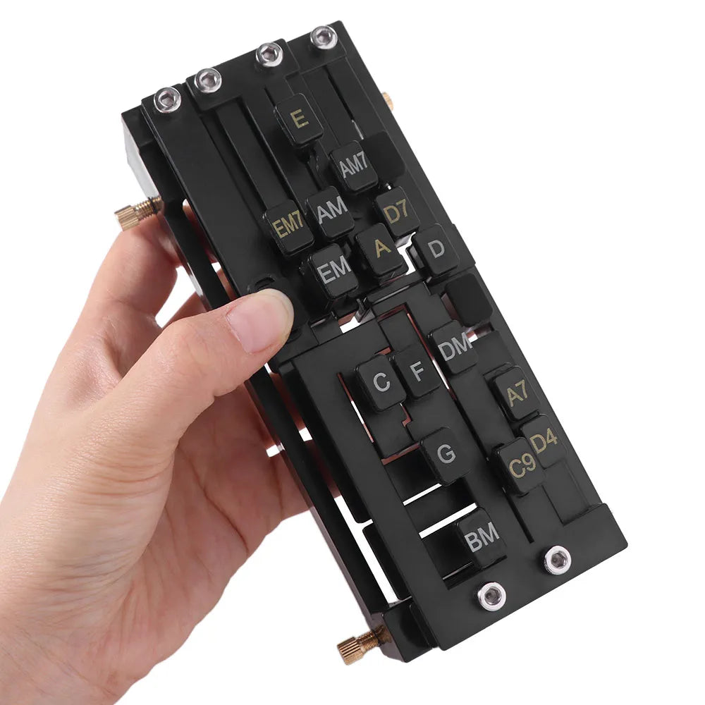 A hand holds a black beginner guitar chord trainer with various chord diagrams and tuning indicators.