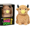 A fluffy brown Scottish Highland cow squishy toy with black horns and yellow face, packaged in a box.