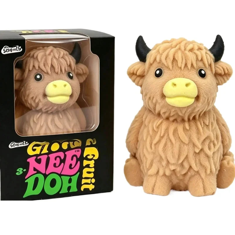 A fluffy brown Scottish Highland cow squishy toy with black horns and yellow face, packaged in a box.