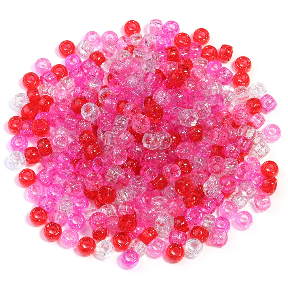 A pile of 200 colorful pony beads in shades of pink and red for DIY jewelry making