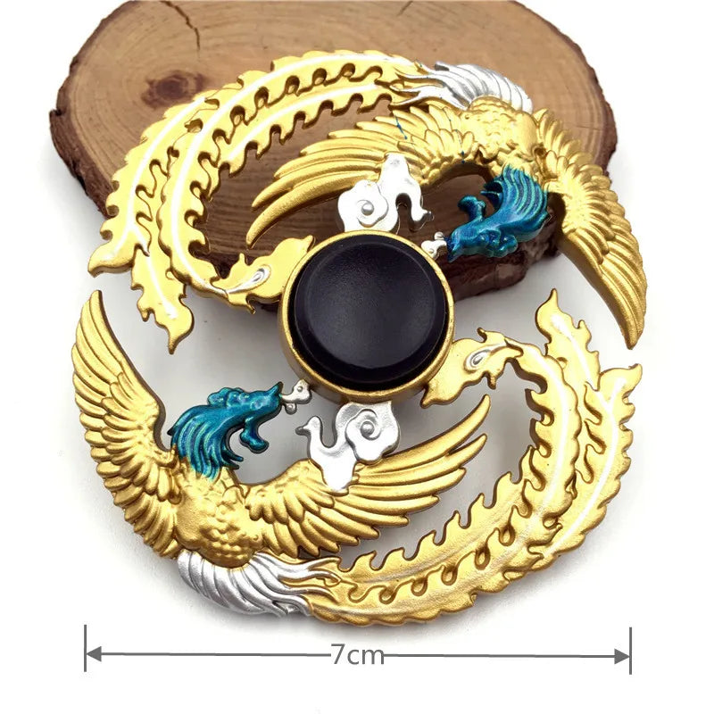 A gold metal fidget spinner featuring a rainbow finish and a black center, resting on a wooden surface.