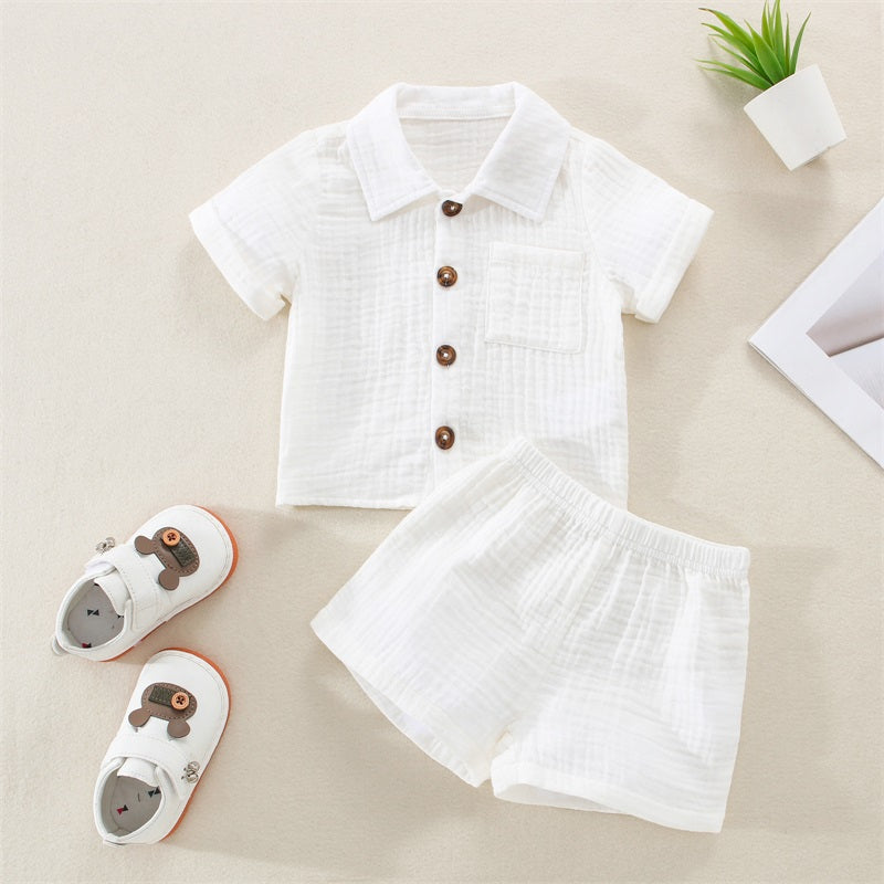 A white baby boy cotton linen summer shirt and shorts outfit set laid out on a light background.