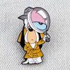 An enamel pin featuring a cartoon dog character wearing a helmet and holding a gun.