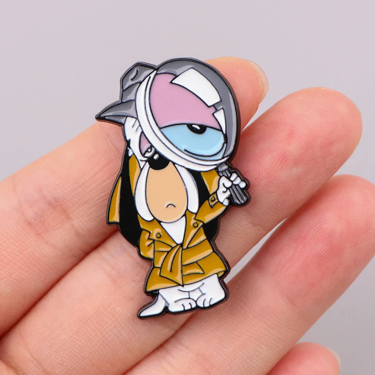An enamel pin featuring a cartoon dog character wearing a helmet and a yellow jacket
