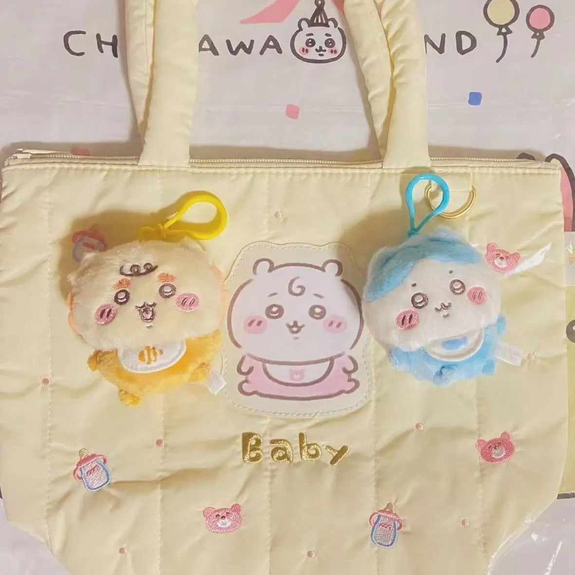 A yellow quilted bag with three plush keychains featuring characters like Usagi, Hachiware, and JiYi.