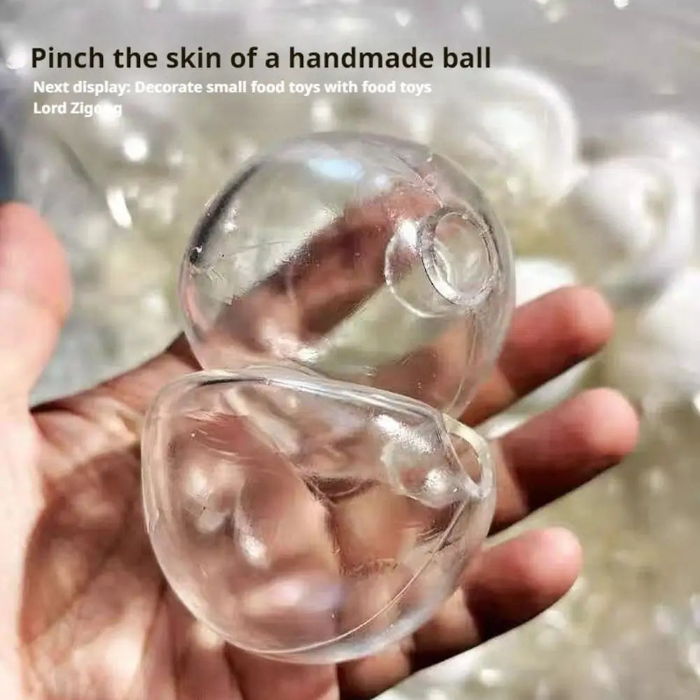 A hand is pinching the skin of a clear, handmade ball used as a squishy stress ball cover.
