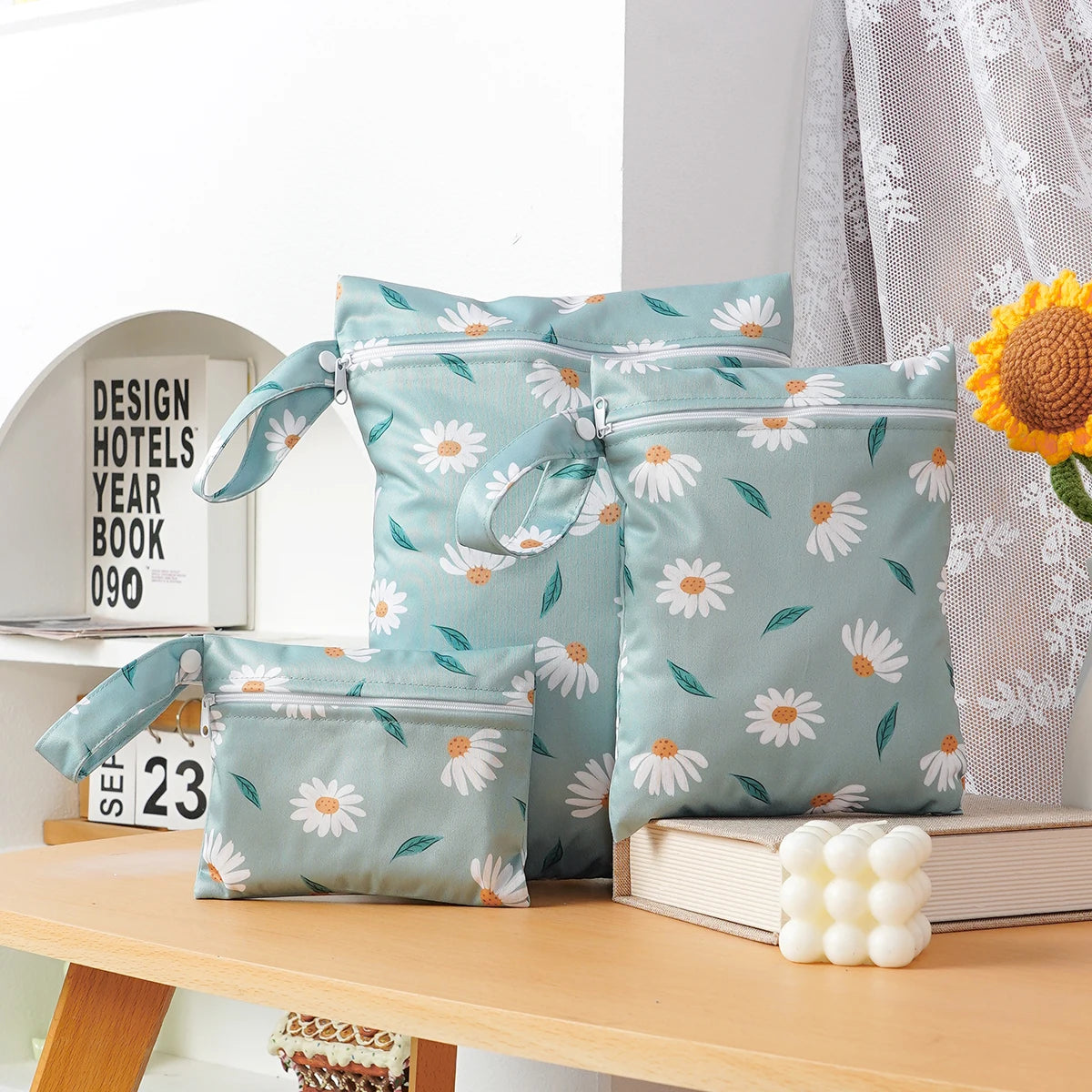 A set of three light blue floral waterproof bags for storing swimsuits, diapers, and travel items.