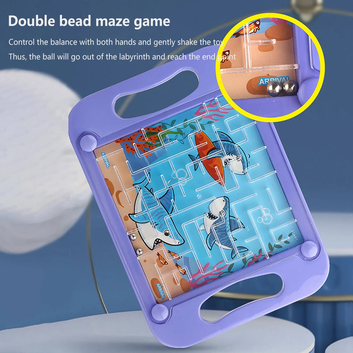 A purple plastic maze game board with colorful fish figures and a ball, showing how to control balance to reach the end point