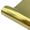 A close-up view of a gold or brass heat transfer vinyl material being rolled or cut.