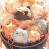 A pile of cute cartoon cat figures in various poses and colors, suggesting a diamond painting kit or craft supplies.