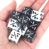A hand holds a set of ten dual-color counting dice showing various positive and negative numbers.